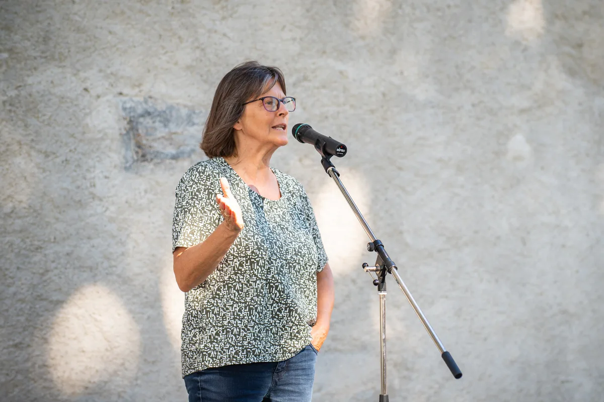 Eine Frau steht an einem Mikrofon. 